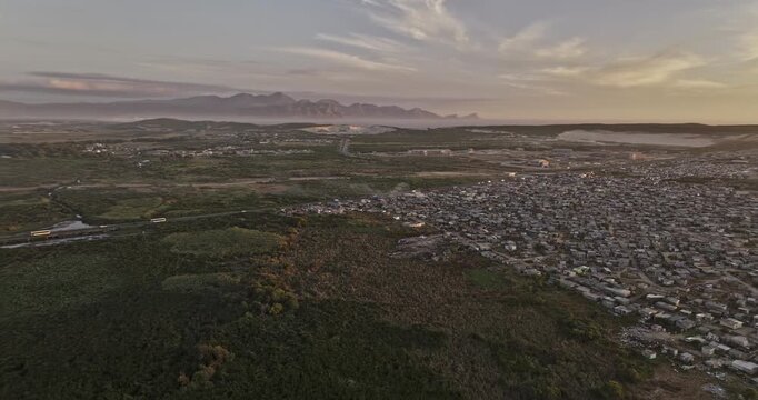 Cape Town South Africa Aerial v111 sunset flyover around Khayelitsha and Macassar township housing toward False Bay and coastal mountains - Shot with Mavic 3 Pro Cine - Jan 11th 2024