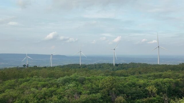 Wind Farm Landscape: A scenic vista showcasing a wind farm with multiple turbines dotting a lush, green landscape under a vast sky, representing renewable energy and sustainable power generation.