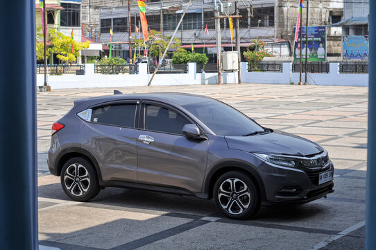 Riau-Indonesia, august 13 th 2026 : A dark metallic gray Honda HR-V crossover SUV parked in an open plaza area on a sunny day.