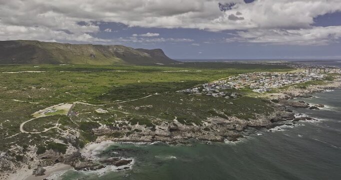 Gansbaai South Africa Aerial v9 flyover around Klipgat Caves and De Kelders shoreline with beach, townscape and coastal mountains - Shot with Mavic 3 Pro Cine - Jan 8th 2024