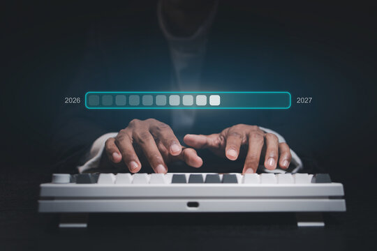 Hands typing on a keyboard with digital progress bar showing the transition from 2026 to 2027, representing New Year technology upgrades, business transformation, system updates and future innovation.