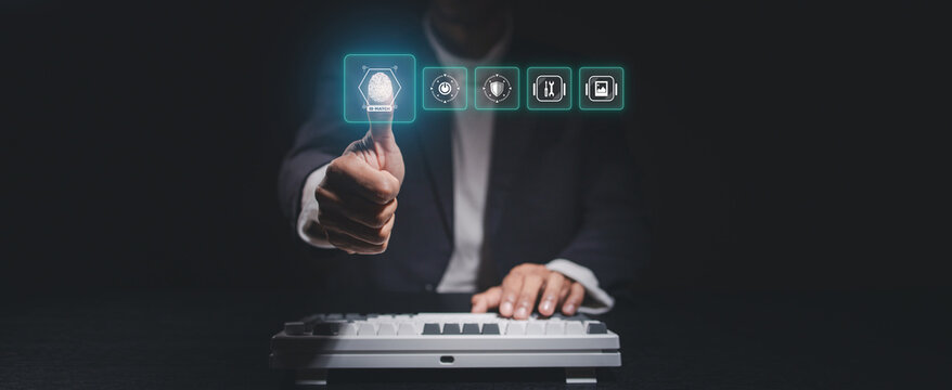 Business professional scanning fingerprint on virtual biometric interface above a keyboard, representing secure login, digital identity verification, cybersecurity, authentication and access control.