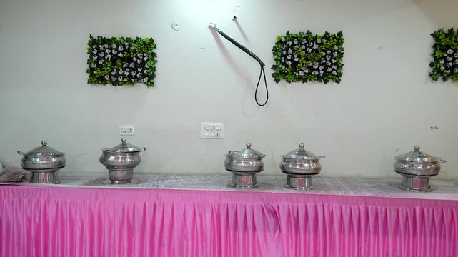 Catering buffet setup with stainless steel chafing dishes at an Indian wedding event.