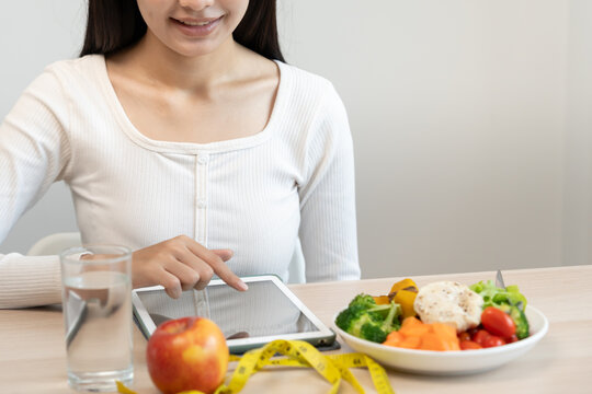 Diet and dieting. Beauty slim female body set diet plan and check calories for healthy food on tablet. weight loss, lose, balance, control, reduce fat, low calories, routines, exercise.