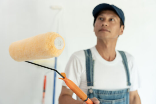 painter man, brush in hand for products to restore and paint the wall, indoor the building site of a house, wall during painting, renovation, painting, contractor, Architect, construction worker