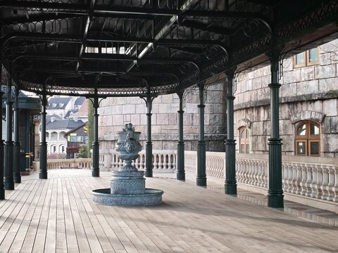 Ba Na, Da Nang, Vietnam - 01 August 2026: View of the ornate fountain at Ba Na Hills SunWorld, featuring a decorative metal basin on a wooden terrace with stone balustrades.