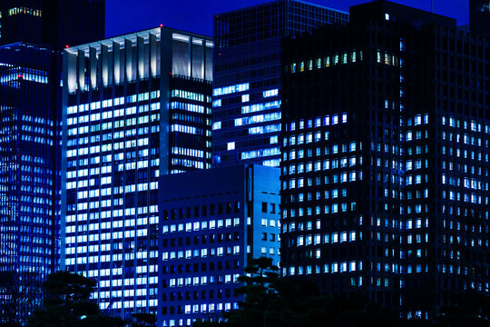 Futuristic cityscape of illuminated office towers, symbolizing corporate stability, high-tech network, and finance.