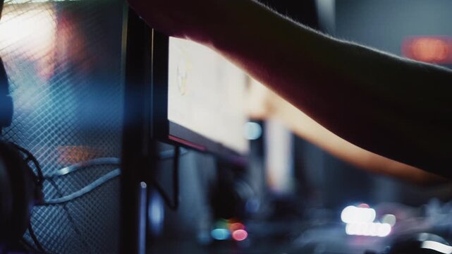 Young gamer adjusting the computer monitor while preparing for an online video game tournament
