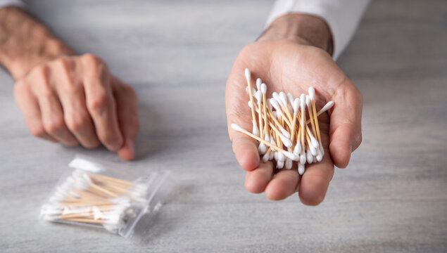 Caucasian man showing cotton bud for ear cleaning.