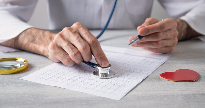 Doctor examining ECG results graph. Health and medicine