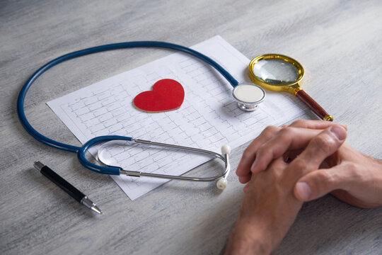 Doctor examining ECG results graph. Health and medicine