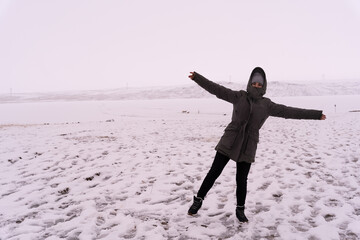 Joyful Woman in Olive Parka with Arms Wide Open in Snowy Landscape © Jenni Ventura Martil