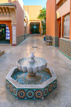 Marrakech, Morocco - 03 January 2024: View of a traditional marble fountain with intricate zellige tile work in the historic Marrakech-Medina, surrounded by warm-toned walls.
