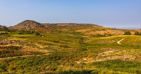 Fototapeta premium Rocky mountain landscape with green vegetation under a clear sky in Portugal