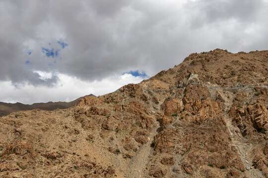 Rocky desert mountain slope under cloudy sky