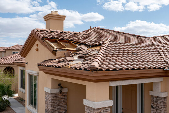 Roof of a house has tiles removed and exposed wood