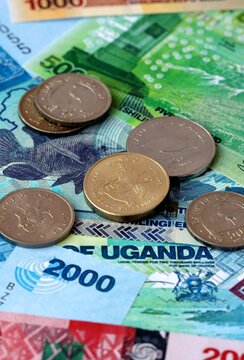 Ugandan shilling money banknotes and coins on table. Uganda cash bills of UGX currency