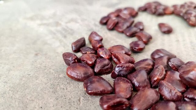 Closeup of fresh brown tamarind seeds piled. Tamarind seeds are effective for relieving dry eyes, lowering cholesterol, aiding digestion, and serving as a natural wastewater purifier