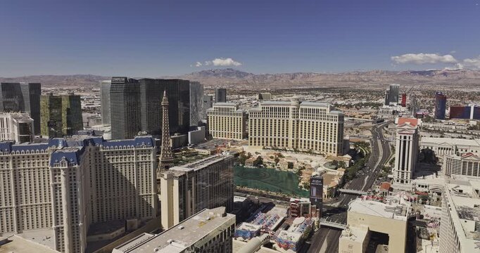 Las Vegas Nevada Aerial v75 low reverse flyover above Flamingo Road, revealing central Strip hotels and rugged desert mountains - Shot with Mavic 3 Pro Cine - Apr 30th 2024