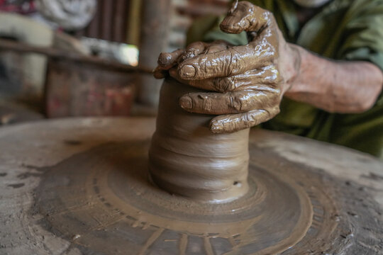 Badgam, Jammu and Kashmir, India - 22 June 2026: View of a potter's hands shaping wet clay on a spinning wheel in the village of Nowbugh, showcasing traditional craftsmanship.