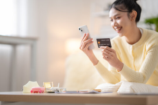 Happy Asian woman using smartphone with credit card, buying travel insurance online, paying vacation expenses, travel booking, digital payment, trip protection concept.