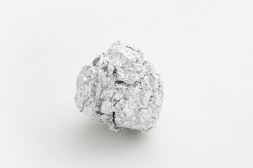 Fototapeta premium Crumpled ball of aluminium foil on white background