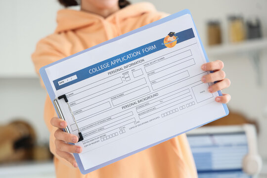 Teenage girl with college application form in kitchen, closeup