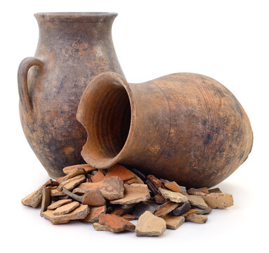 Ancient clay pots and pottery shards isolated on a white background.