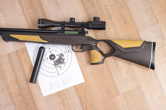 Top View of Scoped Sport Rifle with Ammunition Pellets and Paper Target