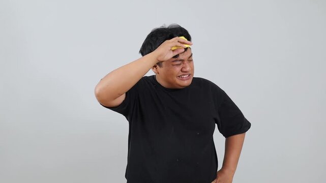 Asian young overweight man is feeling tired isolated over a white background in studio