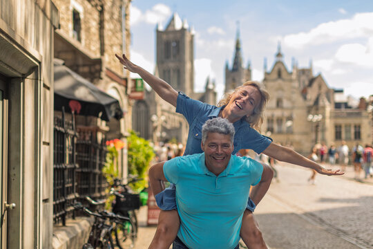 Man giving a woman a piggyback ride in a historic street
