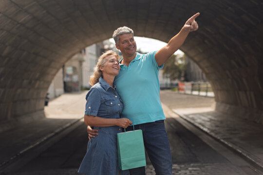 Shoppers looking up at a landmark under a bridge arch