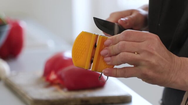Female Hands Sharpening Chef Knife In The Kitchen For Cooking Asian Wok Food