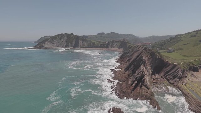 Aerial view of layered rock strata along a rugged coastline