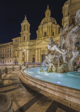 Roma, Italy - 15 October 2021: View of Piazza Navona featuring the illuminated Fountain of the Four Rivers and the baroque facade of Sant'Agnese in Agone at night.
