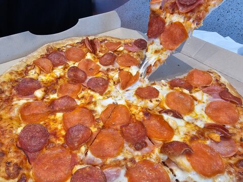 Pepperoni pizza is served with melted cheese