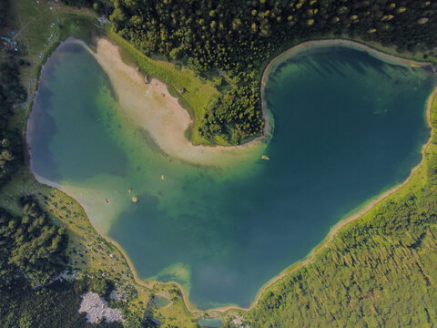 Stunning aerial drone view of the heart-shaped Trnovačko Lake. Trnovačko Lake nestled beneath Maglic, the highest peak in Bosnia and Herzegovina.