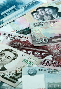 North Korean won money banknotes pile on table. North Korea bills of KPW currency close up