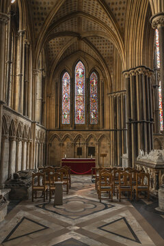 Worcester, England, United Kingdom - 21 July 2026: View of Worcester Cathedral interior featuring stained glass windows, stone arches, wooden chairs, and geometric floor tiles.