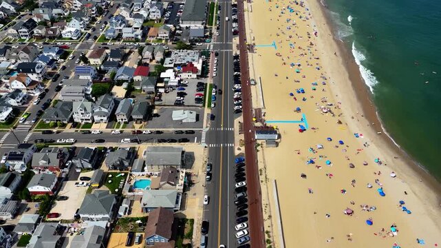 Aerial shot revealing Belmar Beach, ocean, town and traffic on sunny day