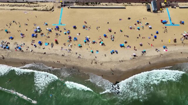Aerial top-down revealing a crowded Belmar Beach, boardwalk and coastal town