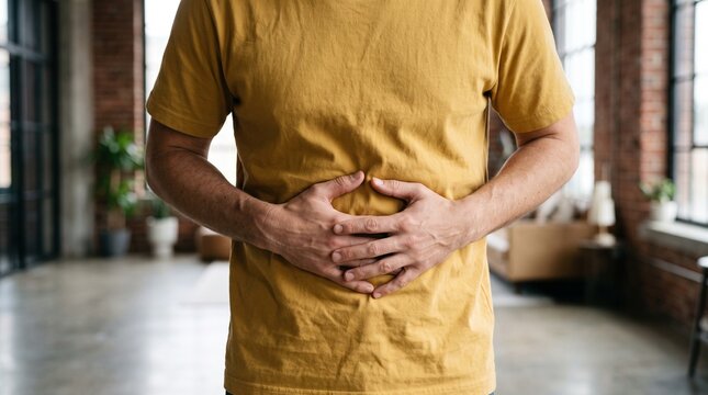 Man holding his stomach suffering from abdominal pain at home.