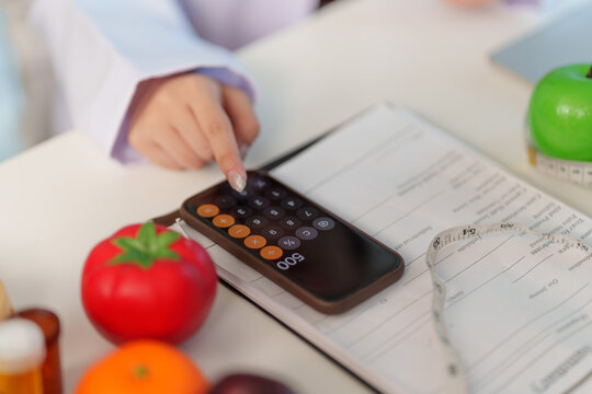 Nutrition consultant calculating meal plan with calculator on smartphone