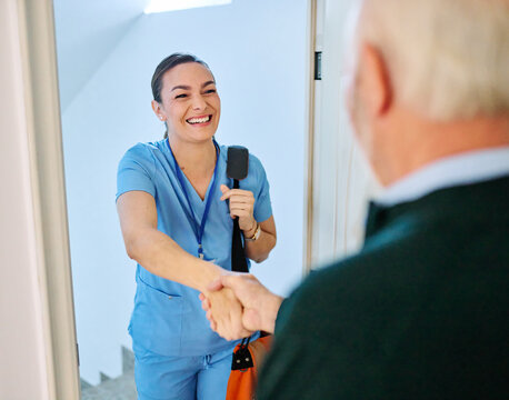 Doctor or nurse caregiver with senior man at home or nursing home, a caregiver standing on the front door arriving and being welcomed by a senior woman