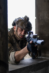 Fototapeta premium Armed military contractor aim assault rifle through window frame. Special operation soldier in tactical helmet focus target in combat