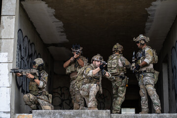 Fototapeta premium Armed special operation force squad holding rifle weapon during tactical urban combat mission inside concrete building