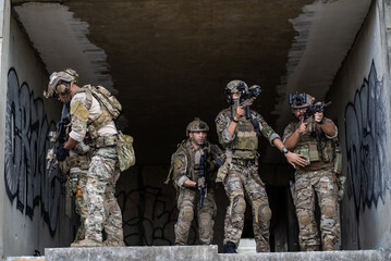Fototapeta premium Special army soldier squad with rifle weapon move together during tactical urban assault operation in ruined building