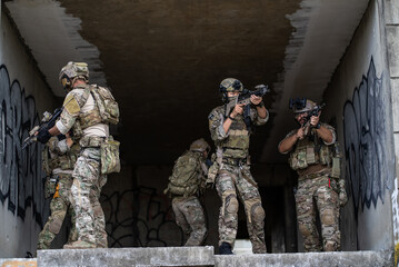 Fototapeta premium Armed special operation force squad holding rifle weapon during tactical urban combat mission inside concrete building