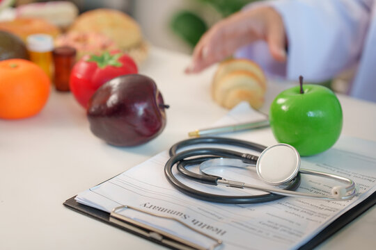 Stethoscope on health summary clipboard in nutrition consultant office with fresh fruits