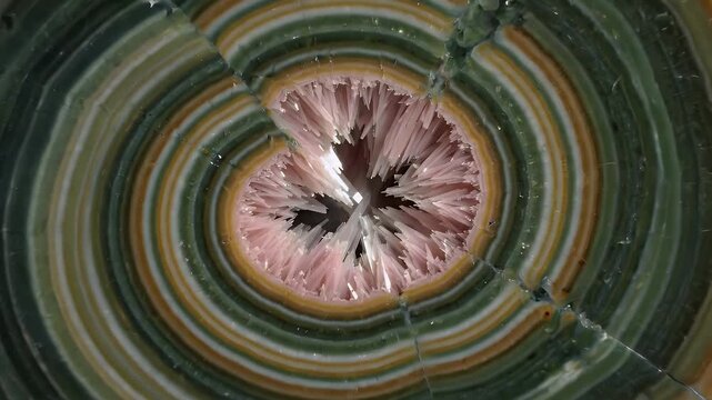 Macro Close-up of Orbicular Jasper Stone with Swirling Pink and Green Bands and Crystalline Interior